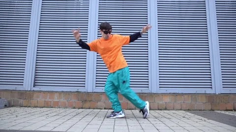Young crazy guy dances hip hop on city street Stock Footage 295068933