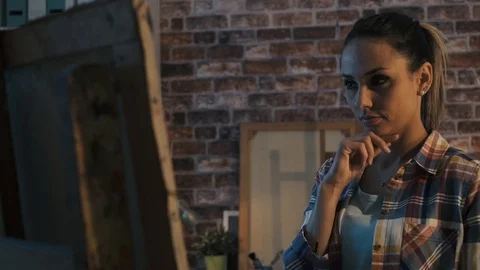 Young creative artist checking her artwork and thinking Stock Footage 90386913