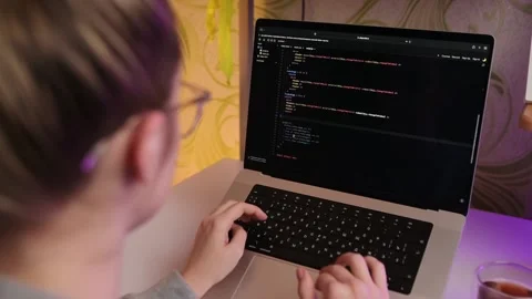 Young creative female developer writes code on her laptop. Stock Footage 219851135