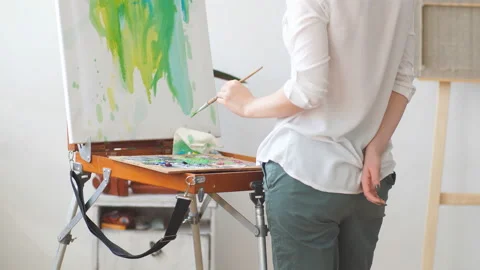 Young creative girl having fun with paint and brush Stock Footage 107764273