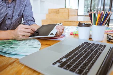Young creative graphic designer working on project architectural drawing and Stock Photos