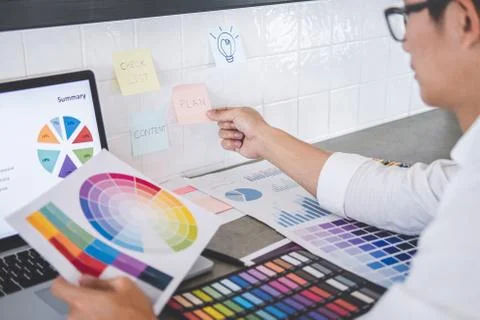 Young creative graphic designer working on project architectural drawing and Stock Photos