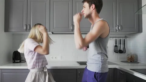 Young creative hipster couple dancing together in the kitchen at home. Fancy Stock Footage 130384374