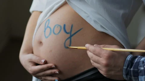 A young creative husband wrote the blue paint on the belly of the word boy. The Stock Footage 61740856