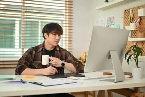 Young creative man looking at computer screen, planning application development Stock Photos