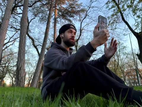 Young Creative Man Recording Video Blog with Smartphone in Scenic Park Stock Footage 332593503