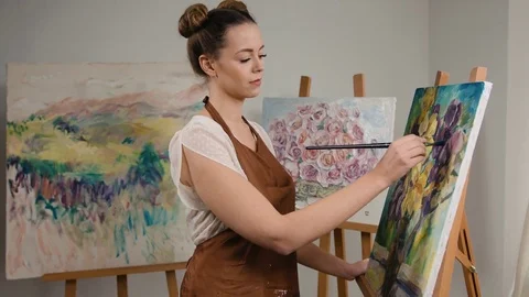 Young creative painter drawing beautiful flowers on canvas in art studio Stock Footage 74206247