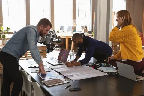 Young creative professionals working in a sunlit office Stock Photos