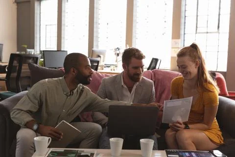 Young creative professionals working in a sunlit office Fotos Stock