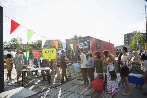 Young crowd waiting in queue at summer music festival entrance Foto stock