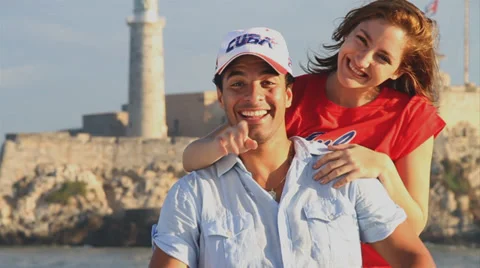 Young Cuban Couple inviting to Cuba to camera in front of Morro Castjle Stock Footage 38763482