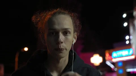 Young curly man drinks tea on the street at night, neon light 2 Stock Footage 96060292