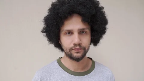 Young curly man looking at the camera and adjusting his hair Stock-Footage 109291399