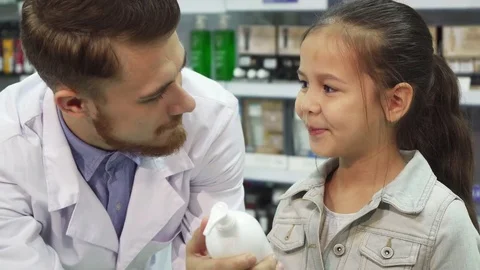 A young customer chooses which item to buy with the help of an apothecary Video stock 81599194