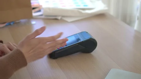 Young customer using Contactless Payment with Mobile Phone in Clothing store Stock Footage 227741767