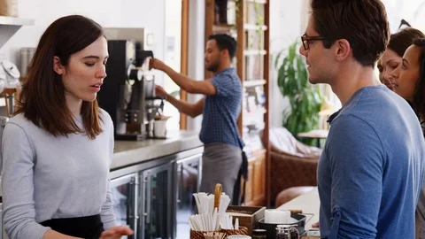 Young customers queuing to order at a coffee shop counter Stock Footage 95960723