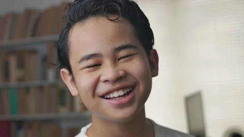 Young cute Asian student boy looking at camera and smiling laughing Stock Footage 143257845