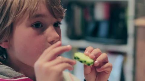 Young cute blonde boy eats pizza with cucumber a la mode Video stock 24276297