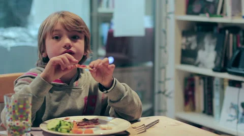 Young cute boy eats pizza but is distracted Stock Footage 24276562