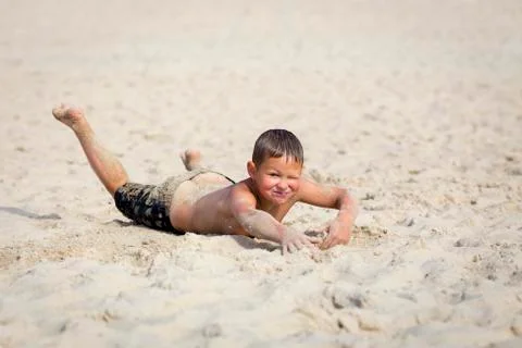 Young cute boy having fun on sand beach. Stock Photos