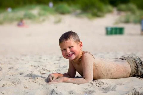Young cute boy having fun on sand beach. Stock Photos