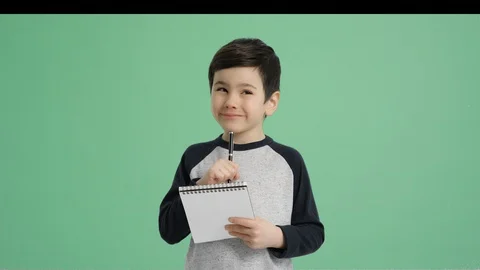 Young cute boy taking notes - Alpha Channel, Green screen Stock Footage 129396176
