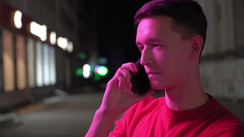 Young cute boy talking on smartphone on the street at night, 4k 5 Video stock 95842564