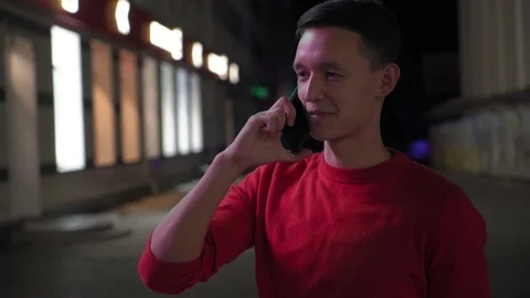 Young cute boy talking on smartphone on the street at night, 4k 4 Stockbeeldmateriaal 95842609