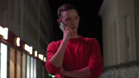 Young cute boy talking on smartphone on the street at night, 4k 3 Stockbeeldmateriaal 95842669