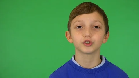 A young cute boy talks to the camera - closeup - green screen studio Vídeo Stock 115074128