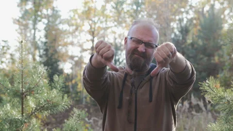 Young, cute dude with beard shows dissent gesture, thumb down Stock Footage 98232337
