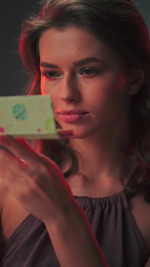 Young cute female model with long hair looking at makeup set Stock Footage 277436336