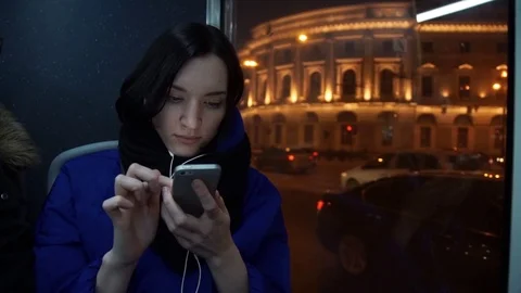 Young cute girl using smart phone with headphones during bus ride Video stock 83872922