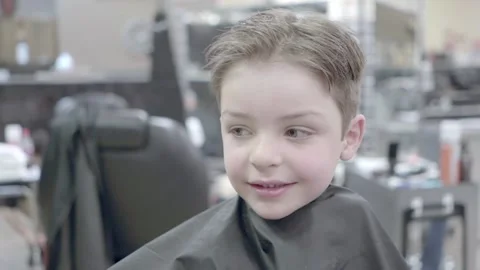 Young cute handsome boy smiling after a haircut in a salon Video stock 169734520