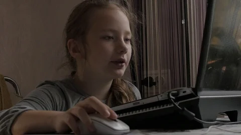 Young cute schoolgirl use laptop searching data in internet for doing homework Stock Footage 96985853