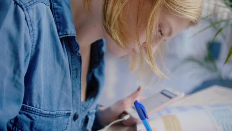 Young cute student doing homework or preparation to exams with help mobile phone Video stock 103285245