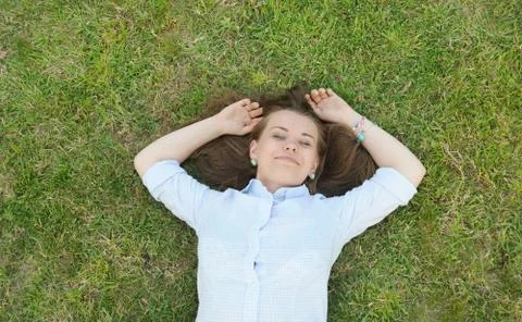 Young cute student having fun on the grass in the park Stock Photos