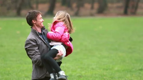 Young dad playing with daughter in park Stock Footage 59554535