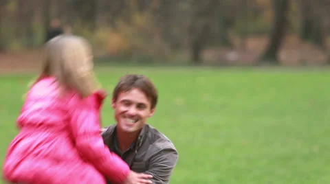 Young dad playing with daughter in park Stock Footage 59554549