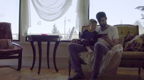 Young dad points out thing on cell phone to child Stock Footage 64383928