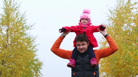 Young Dad with a small child having fun in autumn park Stock Footage 56743829