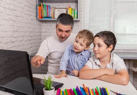 Young dad with sons using laptop looking at screen. Video conference Foto stock