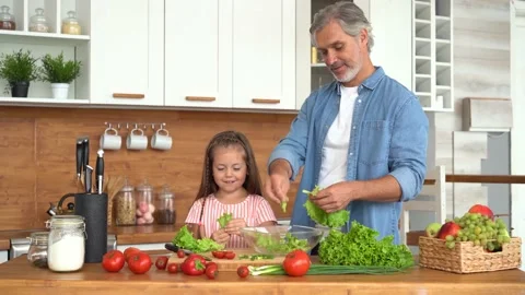 Young dad teaching child learning preparing healthy food cutting vegetable salad Stock Footage 139741444