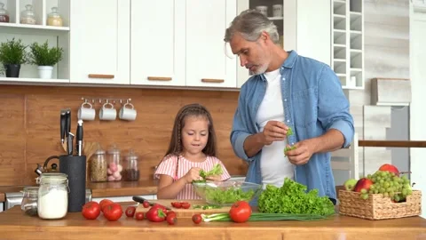Young dad teaching child learning preparing healthy food cutting vegetable salad Stock Footage 139741552