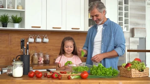 Young dad teaching child learning preparing healthy food cutting vegetable salad Stock Footage 139741554