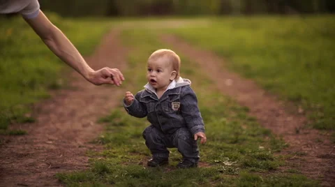 Young dad walking with his son in the park in autumn. Boy wants to eat branch Stock Footage 55118720