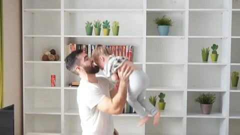 Young daddy doing exercises with his kid Stock Footage 117899004