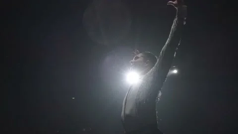 Young dance man in white sparkling shirt in spotlight makes two turns with Stock-Footage 231535922