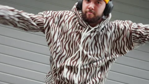 Young dancer man dance move yellow beanie and patterned hoodie performs Stock Footage 292557677