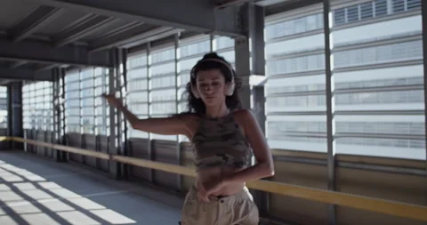 Young dancer performing inside sunlit parking building Stock Footage 213658044